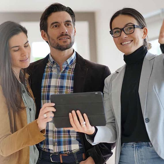 New Home Buying Guide Discovery Tour Three individuals stand before a house holding a tablet in their hands IN & Bowling Green, KY