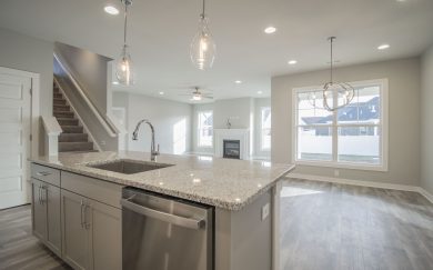 Kitchen Island | Dining Area | Family Room | Stairs to Bonus Spacious kitchen island in the Emory Craftsman floor plan by Jagoe Homes, seamlessly connecting to the dining area and family room, with a view of the staircase leading to the bonus room