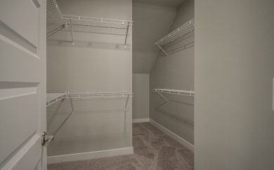 Owner's Closet Owner’s Walk-In Closet in the Emory Craftsman floor plan by Jagoe Homes, featuring ample shelving and hanging space for optimized storage and organization