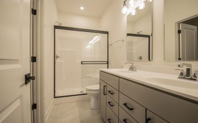 Owner&rsquo;s Bath in the Angelico Craftsman floor plan by Jagoe Homes, featuring a ceramic tile shower and double bowl vanity.