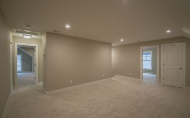 Upstairs loft area with carpet flooring, LED lighting, and access to additional bedrooms and bathroom through the adjoining hallway.
