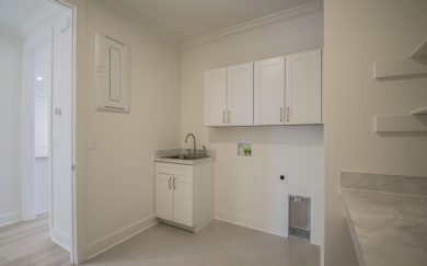 Laundry Room Laundry room featuring a utility sink, wall-mounted cabinets, washer/dryer hookups, folding counter, and ample storage