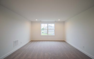 Upstairs bonus room with neutral carpeting, led lighting, and a large window providing natural light and a view of neighboring homes.