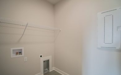 Laundry room in the Leonardo Craftsman with tile flooring, wire shelving, and hookups for a washer and dryer.