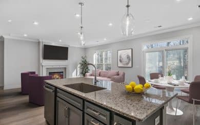 Furnished Great Room with a fireplace and Dining Area in the Arizona Craftsman floor plan by Jagoe Homes.