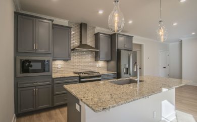Kitchen with optional deluxe features, granite countertops, and a range hood in the Arizona Craftsman floor plan by Jagoe Homes.