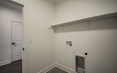 Laundry Room Laundry room with hookups for washer and dryer, upper shelf for storage, and tile flooring.