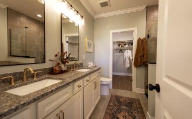 Owner's Deluxe Bath Owner’s deluxe bath featuring a soaking tub, walk-in ceramic shower, and double bowl vanity with granite countertops, plus an Owner’s Closet with MDF shelving in the Carolina Craftsman floor plan by Jagoe Homes.